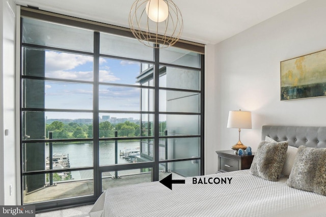 bedroom with a water view, multiple windows, and floor to ceiling windows