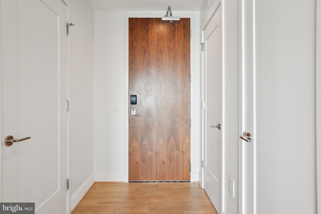hallway featuring baseboards and light wood-type flooring
