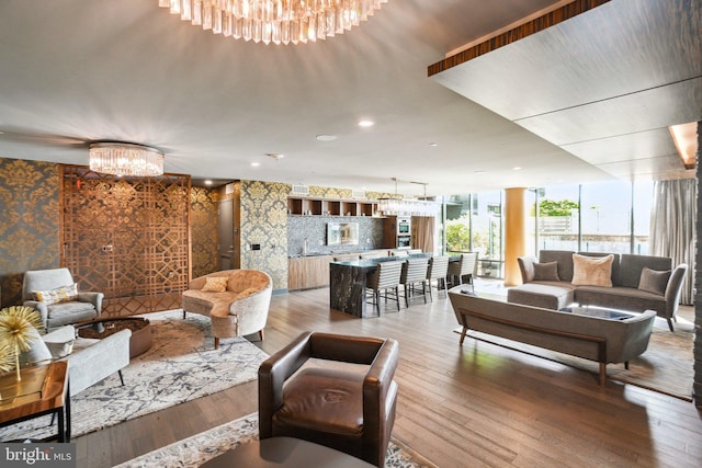 living area featuring a notable chandelier, light wood-style flooring, and recessed lighting