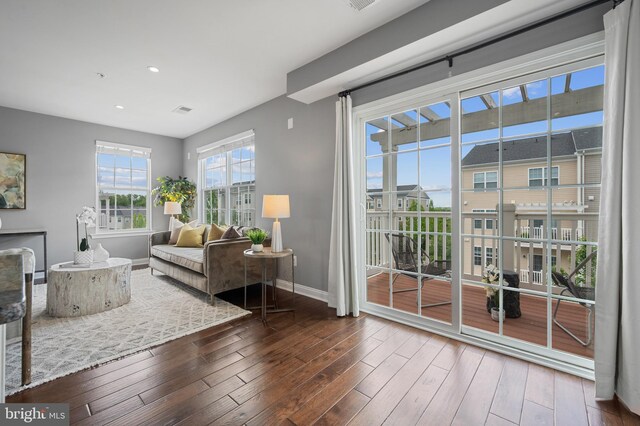 sitting room with baseboards, wood finished floors, and recessed lighting