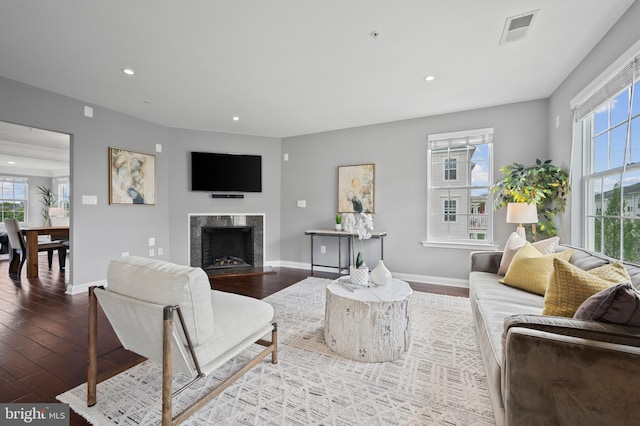 living room with healthy amount of natural light, wood finished floors, baseboards, and recessed lighting