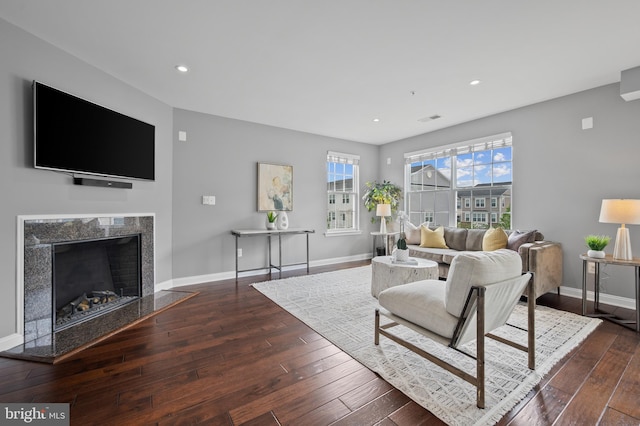 living room featuring hardwood / wood-style flooring, baseboards, recessed lighting, and a fireplace