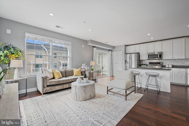living room with dark wood-style floors, recessed lighting, and baseboards