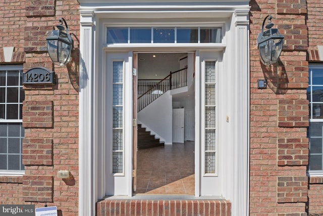 doorway to property featuring brick siding