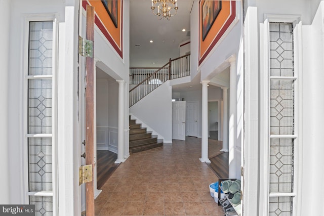 foyer featuring recessed lighting, ornate columns, stairs, and an inviting chandelier