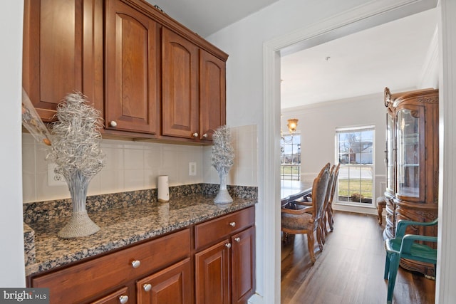 kitchen with brown cabinets, dark wood-style floors, and dark stone countertops