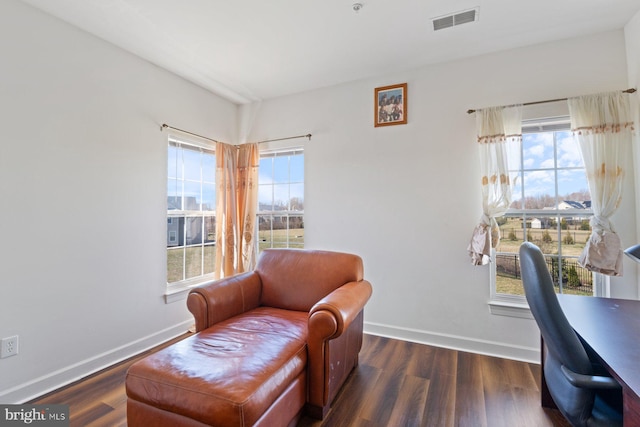 office area with baseboards, a healthy amount of sunlight, wood finished floors, and visible vents