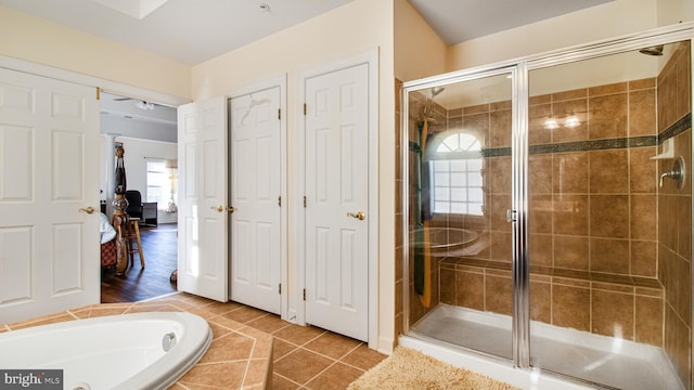 full bathroom featuring a shower stall, ensuite bath, tile patterned flooring, and a relaxing tiled tub