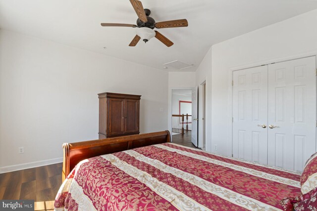 bedroom with wood finished floors, a ceiling fan, a closet, baseboards, and attic access