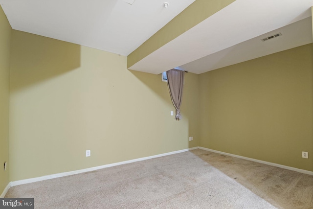 finished below grade area featuring visible vents, baseboards, and carpet flooring