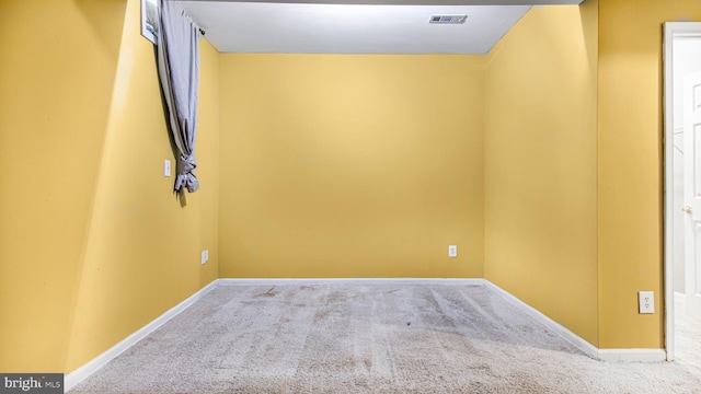 carpeted spare room featuring baseboards and visible vents