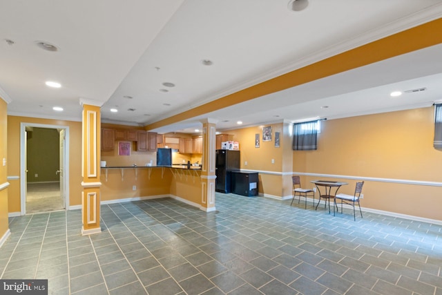 kitchen featuring open floor plan, freestanding refrigerator, recessed lighting, a breakfast bar, and ornamental molding