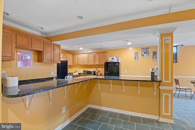 kitchen with stainless steel microwave, black fridge with ice dispenser, a peninsula, fridge, and a breakfast bar area