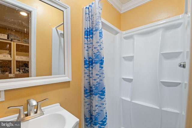 bathroom featuring ornamental molding, a shower with shower curtain, and a sink