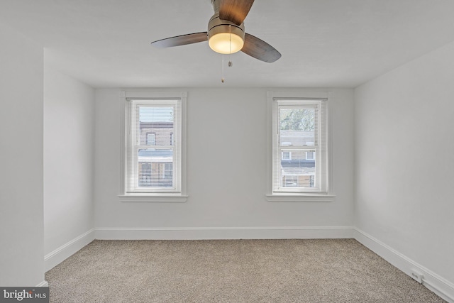 empty room featuring baseboards, ceiling fan, and light carpet