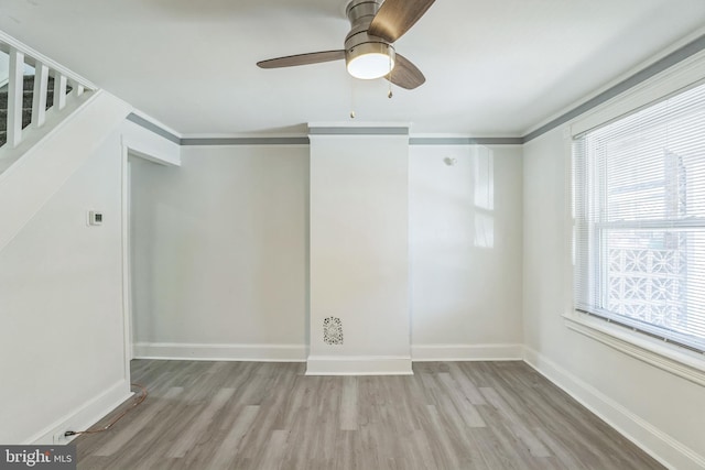 empty room featuring baseboards, ceiling fan, and wood finished floors
