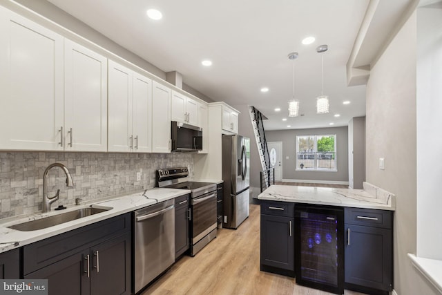 2954 Cedar St, Philadelphia, PA 19134 - kitchen with beverage cooler, stainless steel appliances, a sink, tasteful backsplash, and white cabinetry