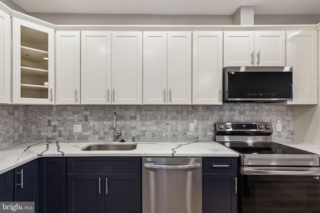 2954 Cedar St, Philadelphia, PA 19134 - kitchen with decorative backsplash, white cabinetry, stainless steel appliances, and a sink