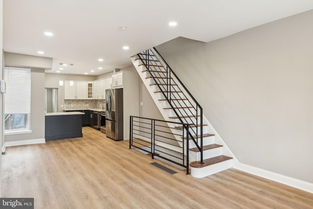 2954 Cedar St, Philadelphia, PA 19134 - stairs with baseboards, wood finished floors, visible vents, and recessed lighting