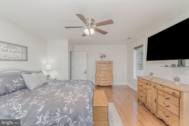 bedroom with a ceiling fan, baseboards, and light wood-type flooring