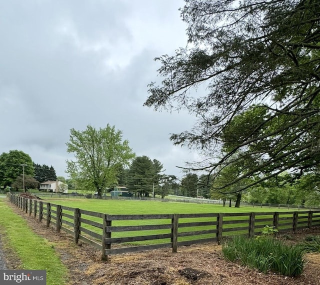 view of yard with fence and a rural view