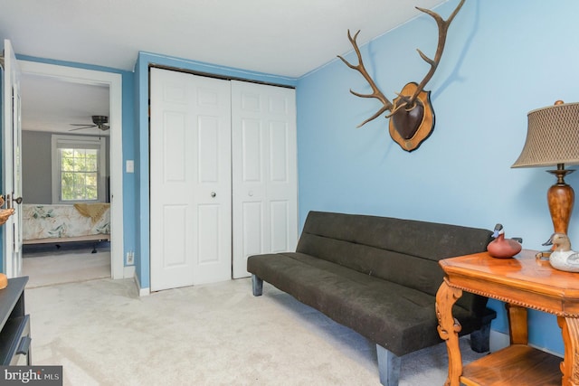 living area with carpet floors and ceiling fan