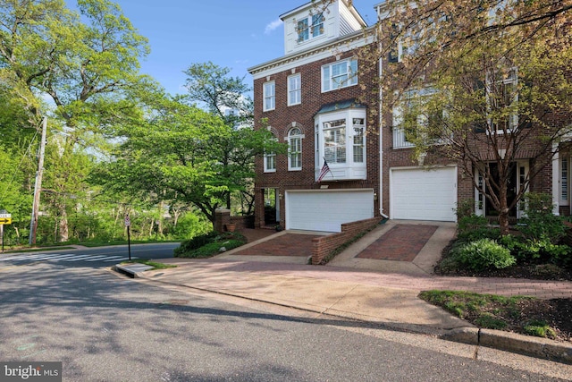 view of front facade with brick siding, decorative driveway, and a garage