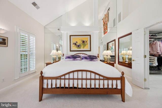 carpeted bedroom with high vaulted ceiling, baseboards, and visible vents