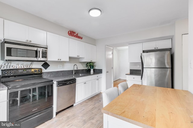 7329 Split Rail Ln, Laurel, MD 20707 - kitchen with stainless steel appliances, a sink, white cabinets, and light wood-style floors