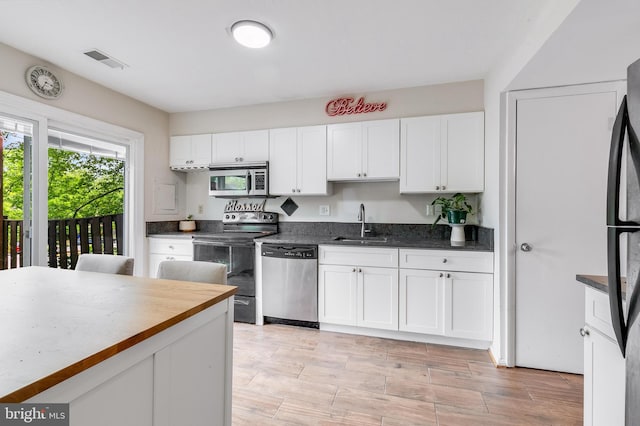 7329 Split Rail Ln, Laurel, MD 20707 - kitchen featuring stainless steel appliances, a sink, white cabinets, and light wood-type flooring