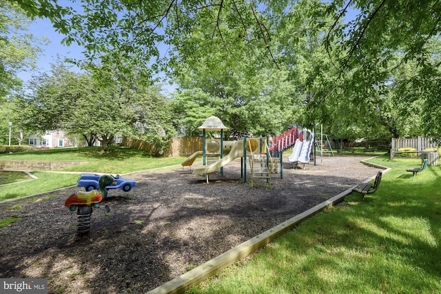 community playground featuring a yard and fence