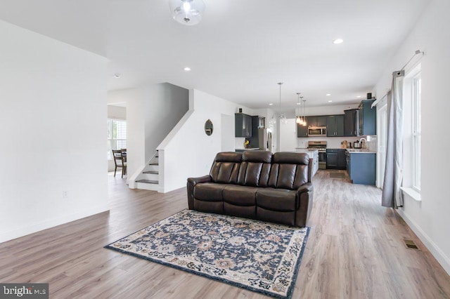 living area with recessed lighting, stairs, light wood finished floors, baseboards, and visible vents