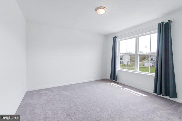carpeted spare room with baseboards