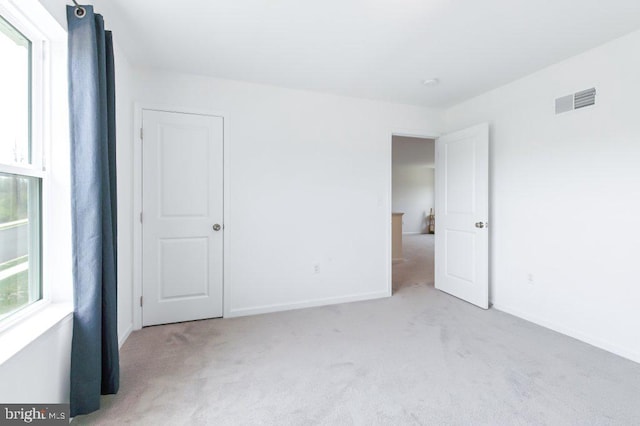 unfurnished bedroom featuring baseboards, visible vents, and carpet floors