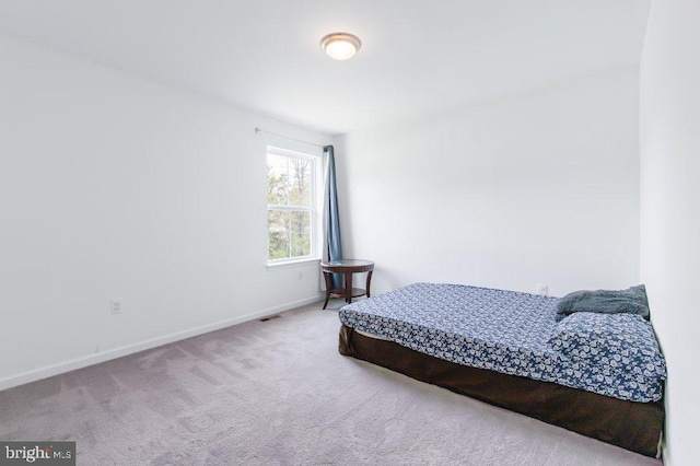 bedroom with carpet floors, visible vents, and baseboards