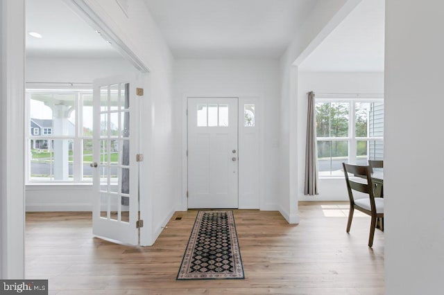 foyer entrance with wood finished floors and baseboards