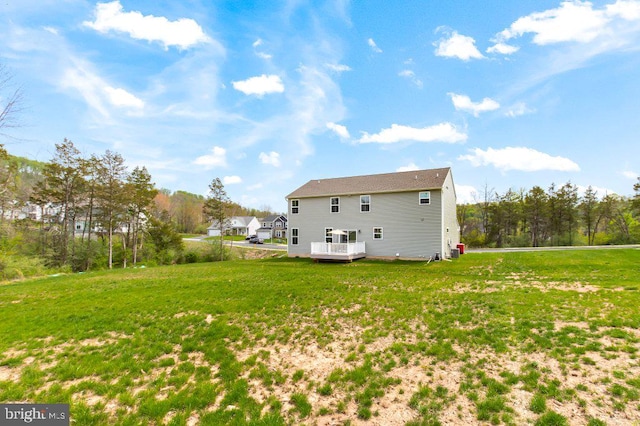 rear view of property with a lawn and a wooden deck
