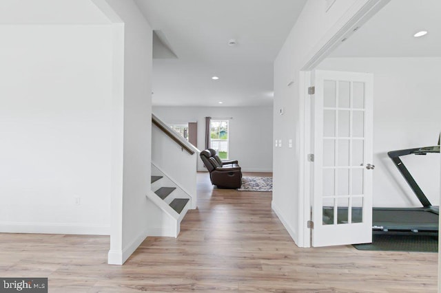 staircase featuring wood finished floors, recessed lighting, and baseboards