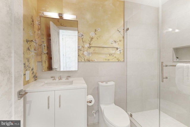 full bathroom featuring vanity, a tile shower, and toilet