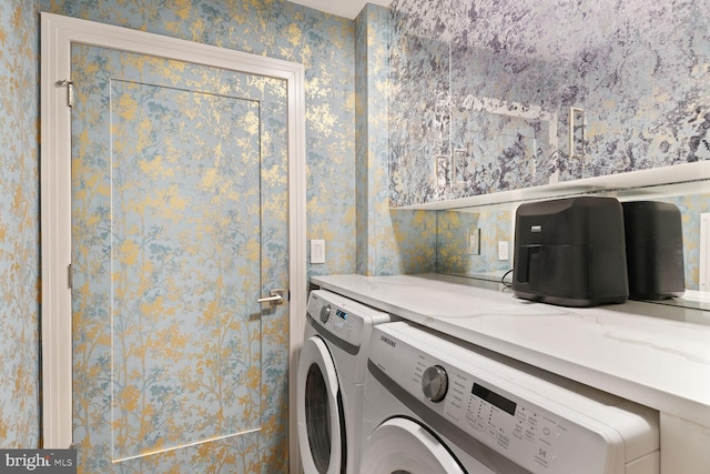 washroom featuring laundry area, wallpapered walls, and washer and clothes dryer