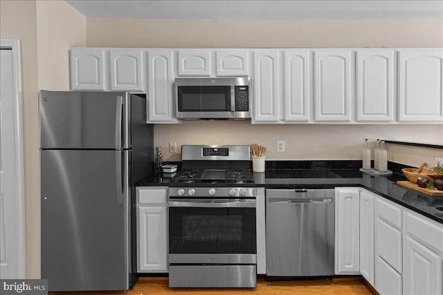 kitchen with white cabinets, dark stone counters, and stainless steel appliances