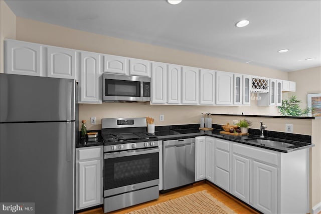 kitchen featuring white cabinets, stainless steel appliances, and a sink