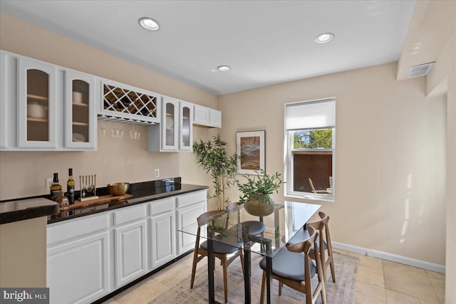 dining room with light tile patterned floors, indoor wet bar, baseboards, visible vents, and recessed lighting