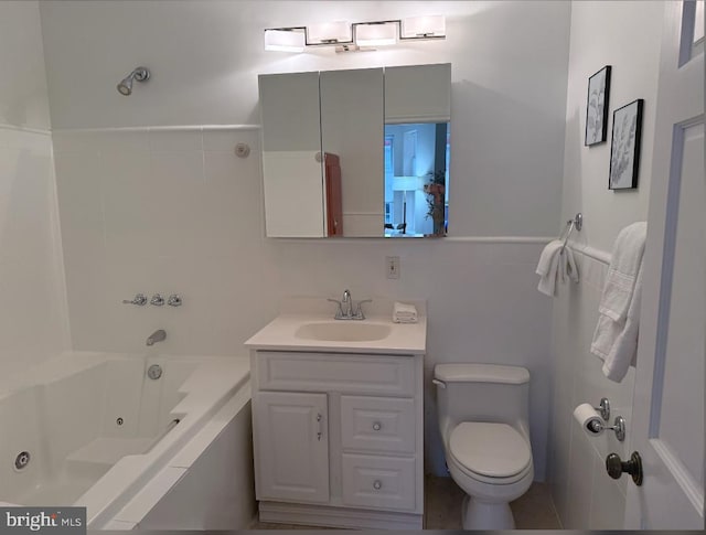 bathroom featuring tile walls, a combined bath / shower with jetted tub, vanity, and toilet
