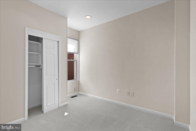 unfurnished bedroom with baseboards, carpet flooring, visible vents, and a closet