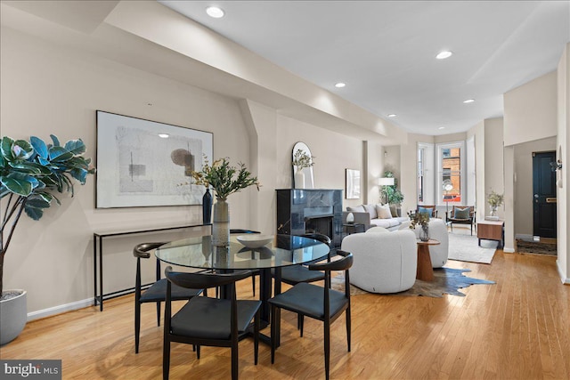 dining space featuring light wood-style flooring, baseboards, and recessed lighting