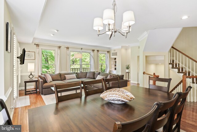 dining area with light wood-style floors, a chandelier, recessed lighting, visible vents, and stairway