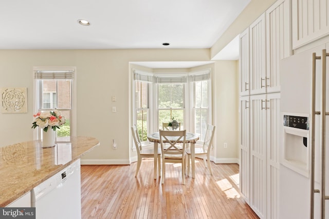 dining room featuring plenty of natural light, light wood-style flooring, and baseboards