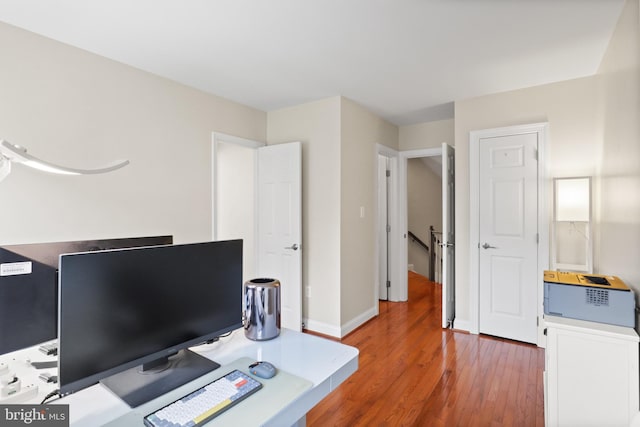 home office with baseboards and wood finished floors