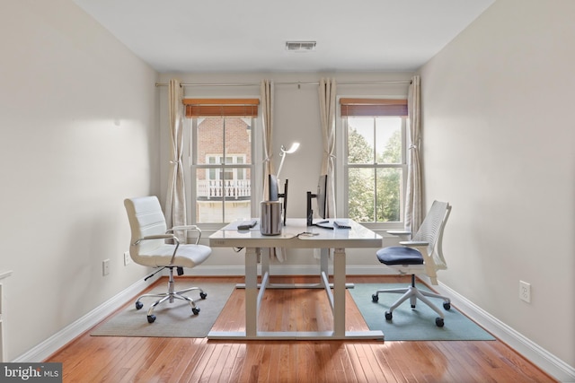 home office with baseboards, wood-type flooring, and visible vents